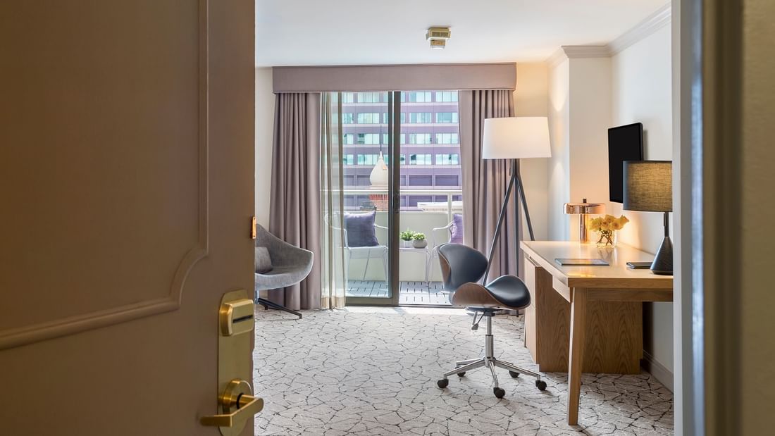 View of Accessible Deluxe Rooms by a balcony under a tripod lamp through an open doorway at Warwick Denver