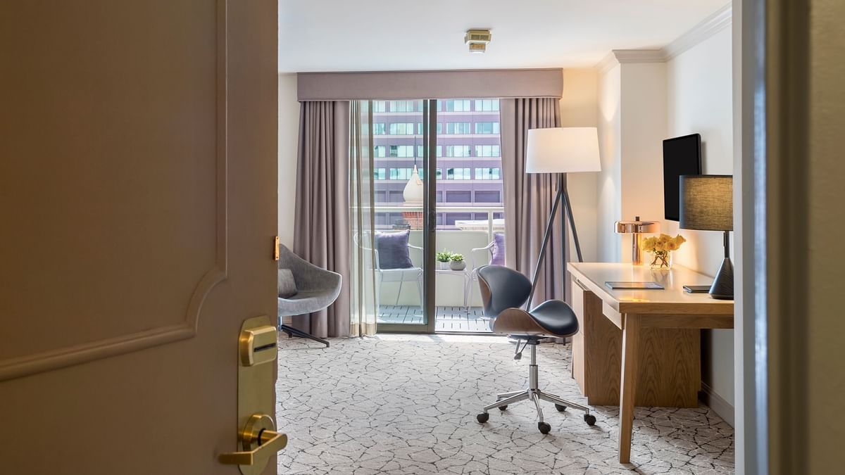 View of Accessible Deluxe Rooms by a balcony under a tripod lamp through an open doorway at Warwick Denver