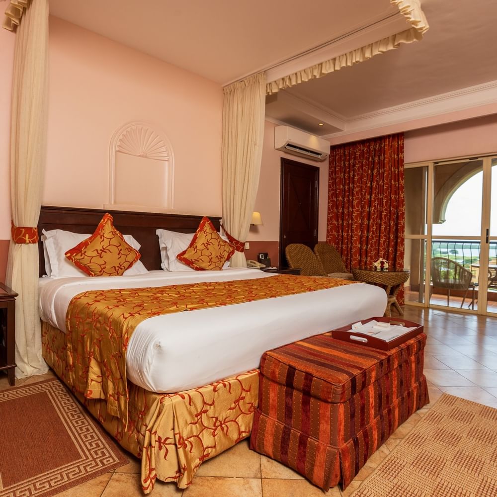 Elegant Standard Deluxe Room with a large bed and balcony view at Lake Victoria Serena Golf Resort & Spa in Kampala.