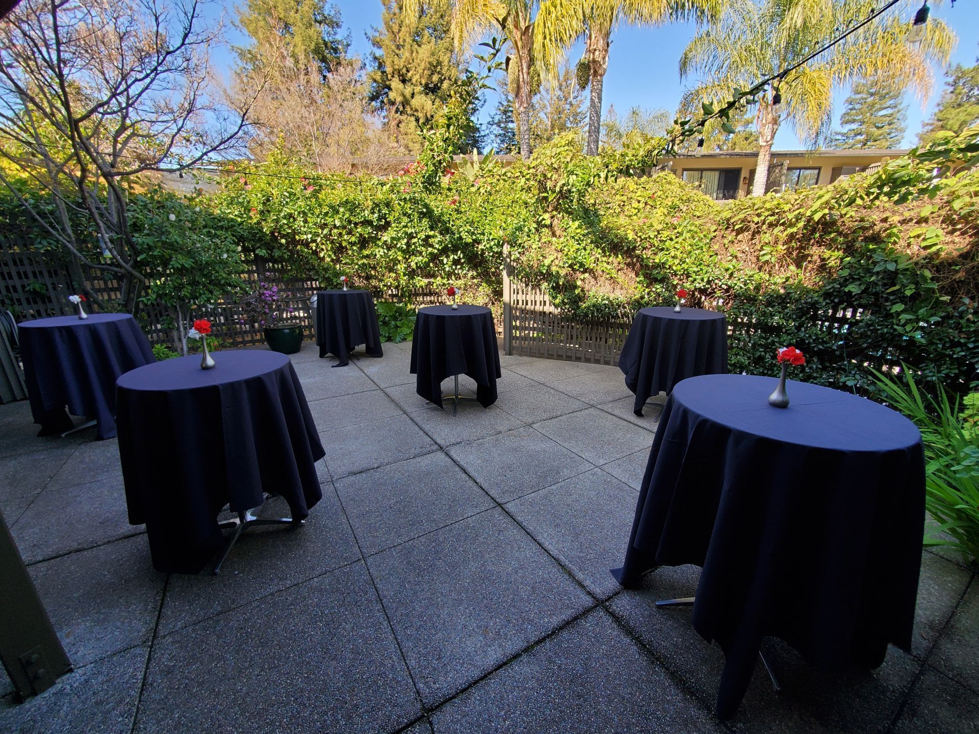 High round tables arranged in The Lanai at Dinah's Garden Hotel
