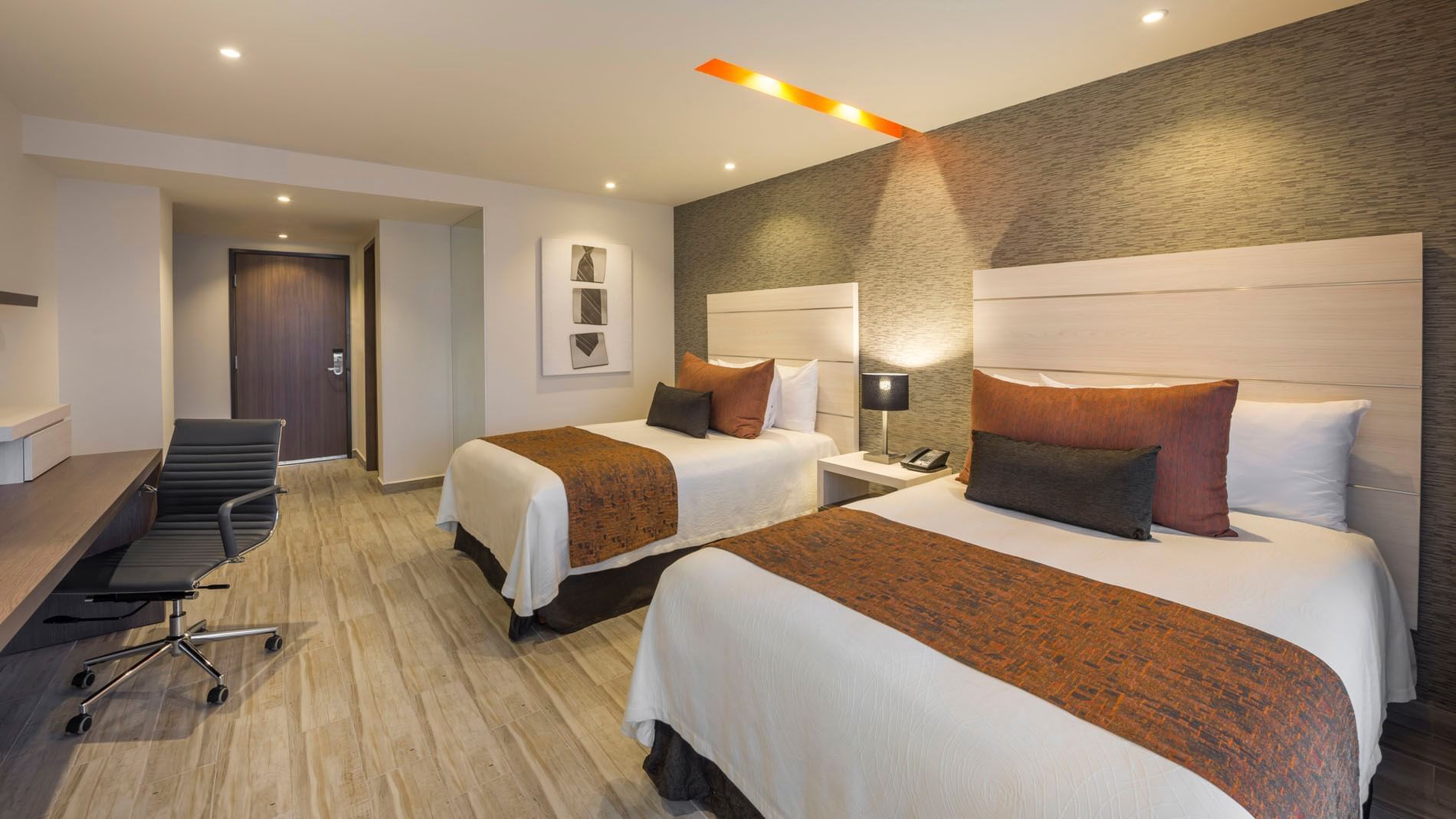 2 Double Deluxe bedroom with textured gray walls, stylish headboards, and warm lighting at Real Inn Celaya