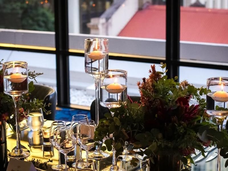 Dining table setup with candles, glassware, and a floral centerpiece in Prive at Sofitel Brisbane Central