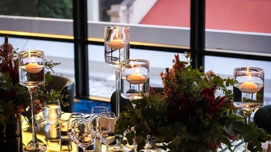 Table setting with stacked wine glasses and floating candles in Privé at Sofitel Brisbane Central