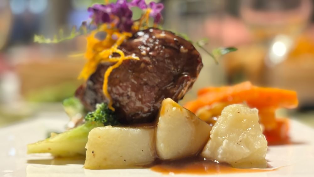 Meat, potatoes, and vegetables on a plate at Wild Ginger Restaurant & Bar in Efate at Warwick Le Lagon - Vanuatu.