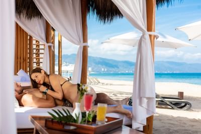 Couple relaxing on beach cabana near Villa Premiere Boutique Hotel & Romantic Getaway