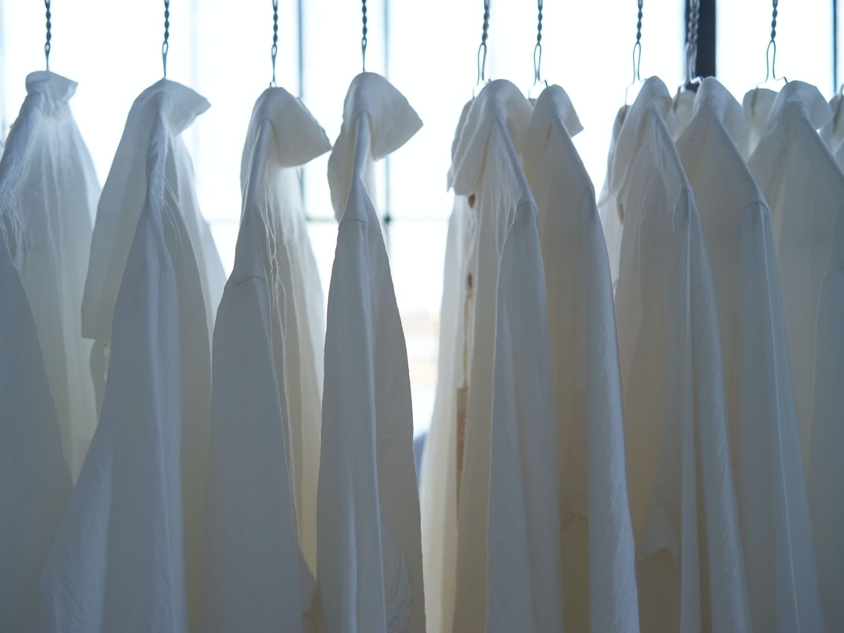 Close-up of clothes hanging on a rack in the Laundry at Po Hotel Semarang