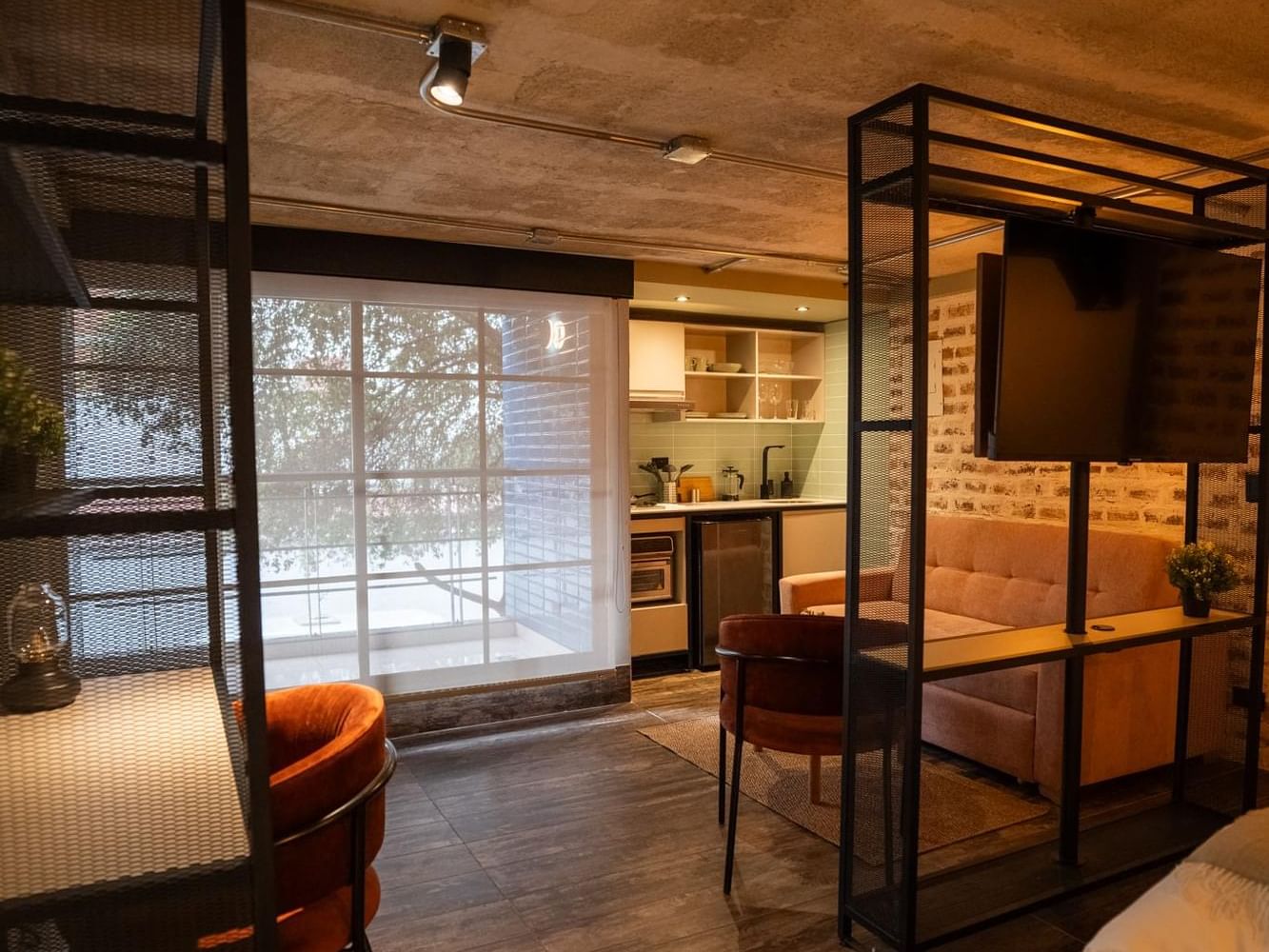 Moderno estudio con acogedores asientos, cocina y separador de TV que combina comodidad y estilo en Estudio con Balcón en 5Q House Zona G