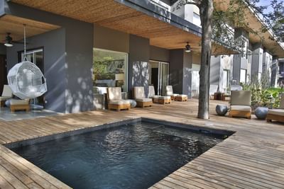 Modern patio with a small pool, wooden deck and hanging chair at El Mangroove Hotel