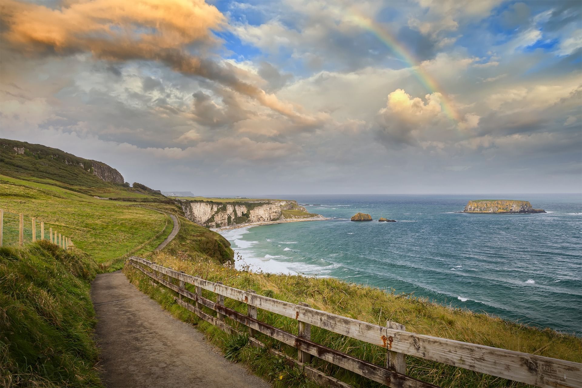 Carrick-a-Rede Rope Bridge with the ocean and greenery near Dunluce Lodge