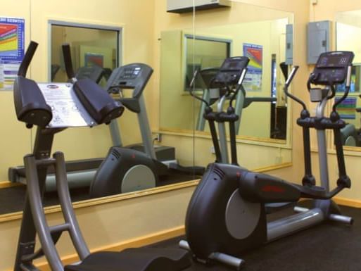 Gym with treadmills, stationary bikes and mirrors on the wall at All Seasons Resort Europa