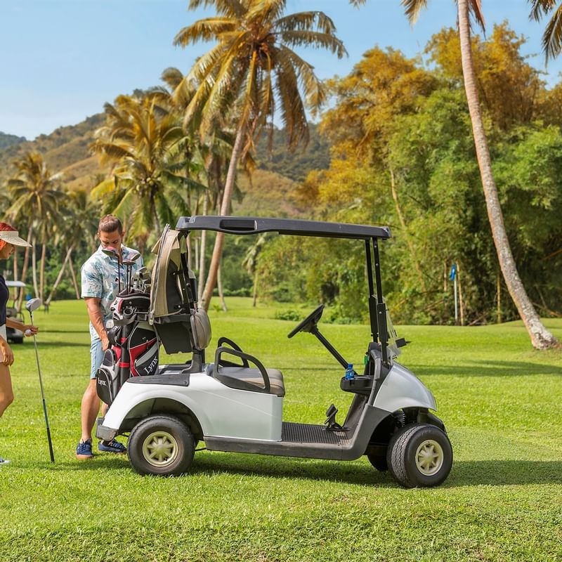 A Couple by a golf kart in a Golf Course at The Naviti Resort - Fiji
