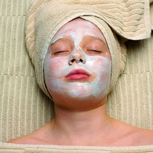 Woman having a facial in the spa at Falkensteiner Hotels