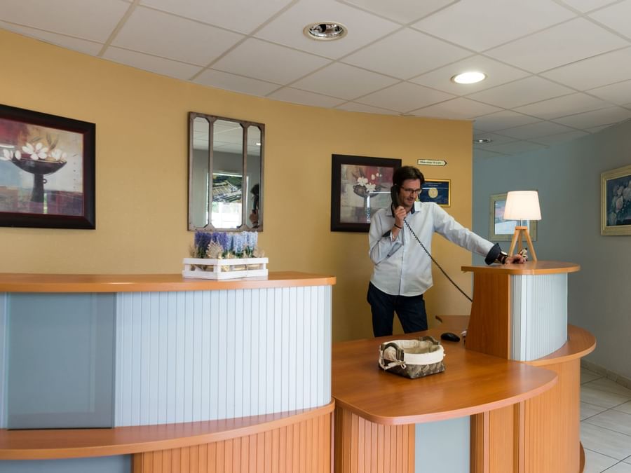 A receptionist at the reception desk in Hotel Pic Epeiche