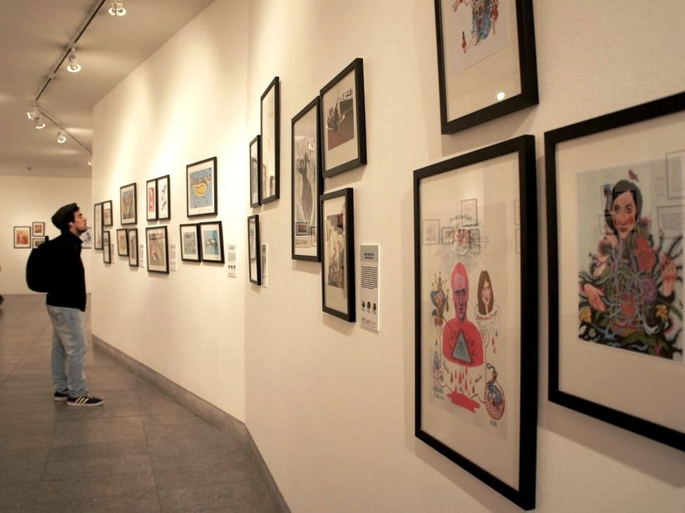 Boy looking at wall pictures in Plop! Galería at Hotel Ismael