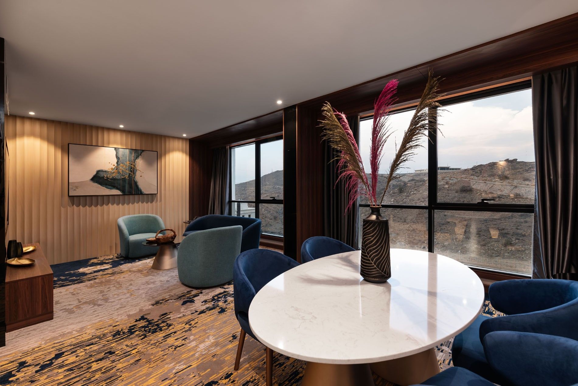 Lounge and dining table by the window with hillside view in the Royal Suite at Warwick Al Taif Hotel