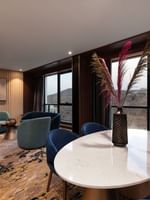 Lounge and dining table by the window with hillside view in the Royal Suite at Warwick Al Taif Hotel