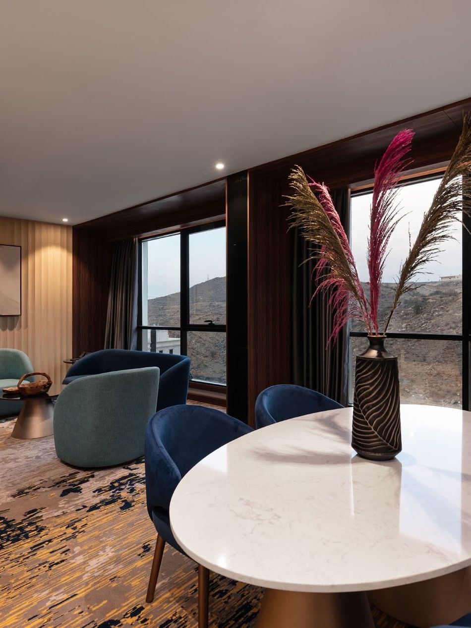Lounge and dining table by the window with hillside view in the Royal Suite at Warwick Al Taif Hotel