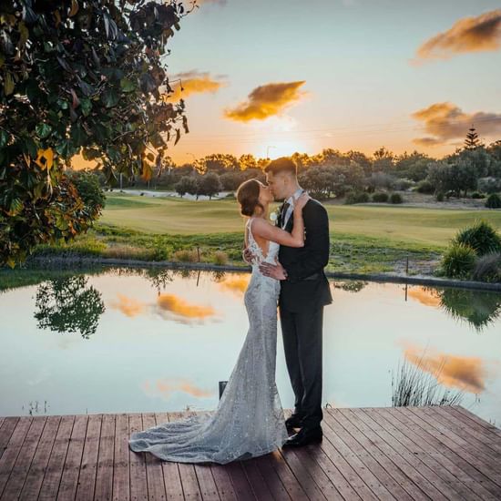 Beautiful couple on wedding day at lakeside for sunset at central coast wedding venue