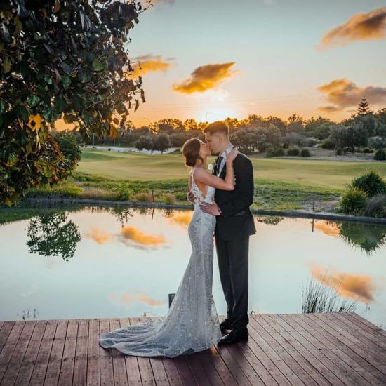 Wedding couple kissing by the lake near Pullman Magenta Shores