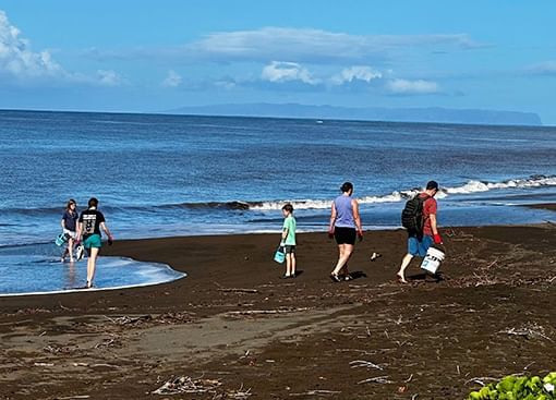 A family removes waste on Waimea Beach