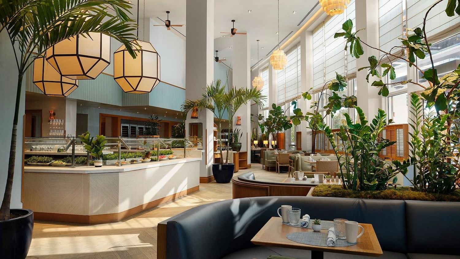 Bright Mediterranean-inspired dining room with buffet stations and sunlit seating.