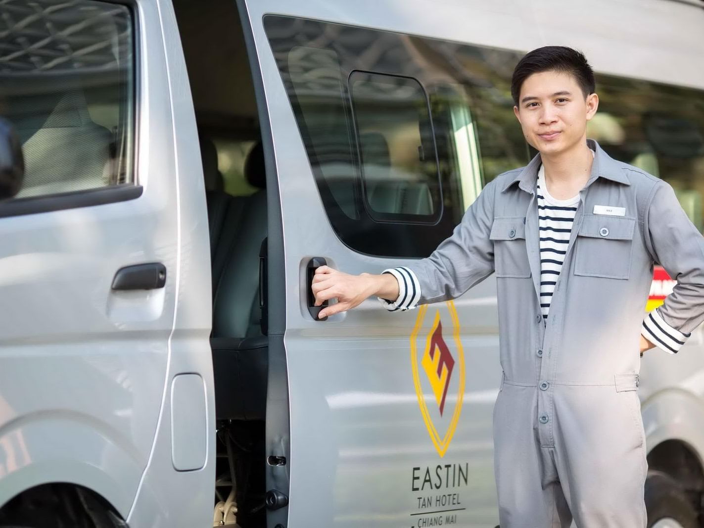 A valet opening the door of a van at Eastin Tan Hotel Chiang Mai