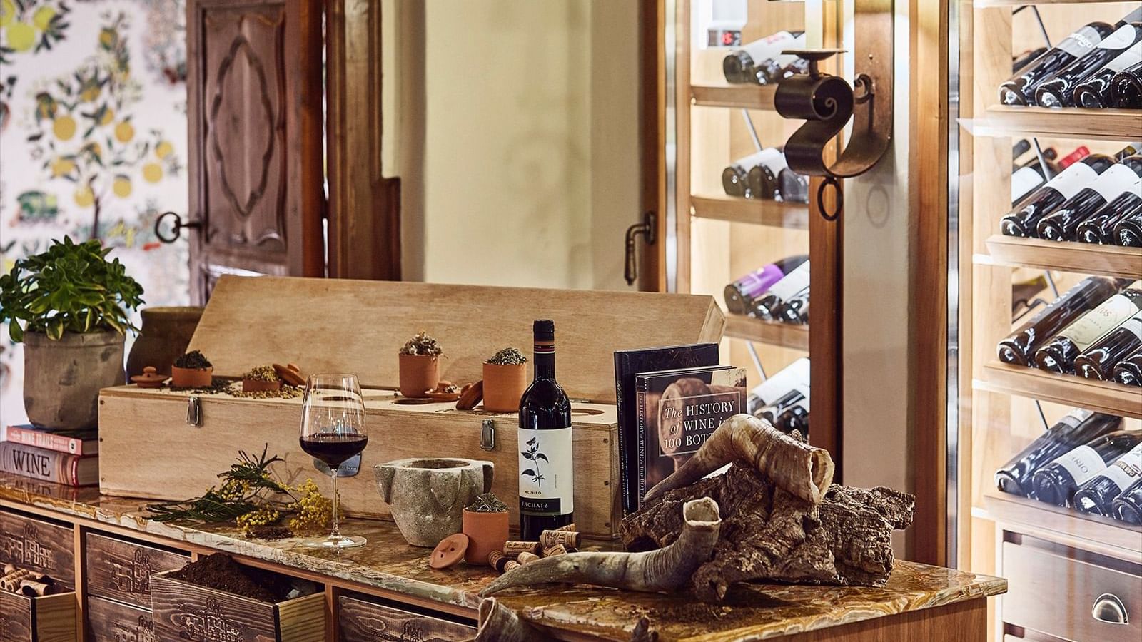 Wine bottle and book placed on a wooden counter with cork and drinking horns at Marbella Club