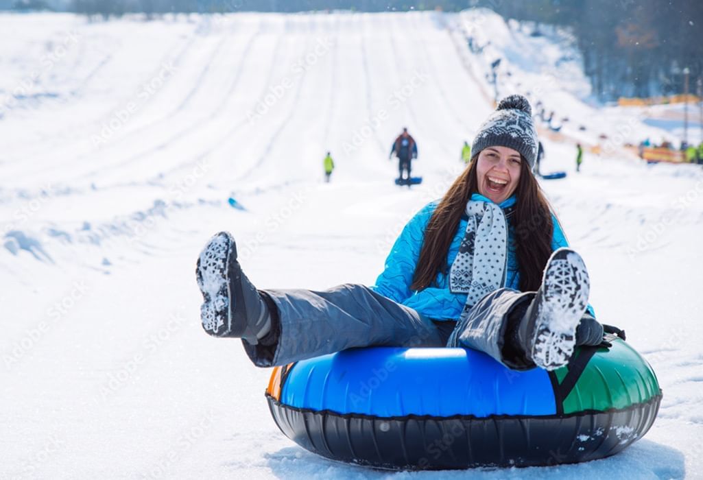 girl smiling riding a tube in a winter park