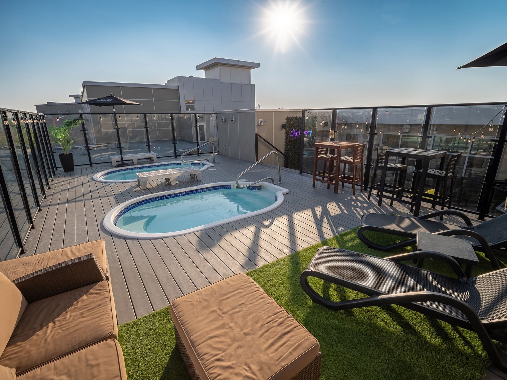 Two rooftop hot bathtubs with arranged seating at Hotel Clique Calgary Airport