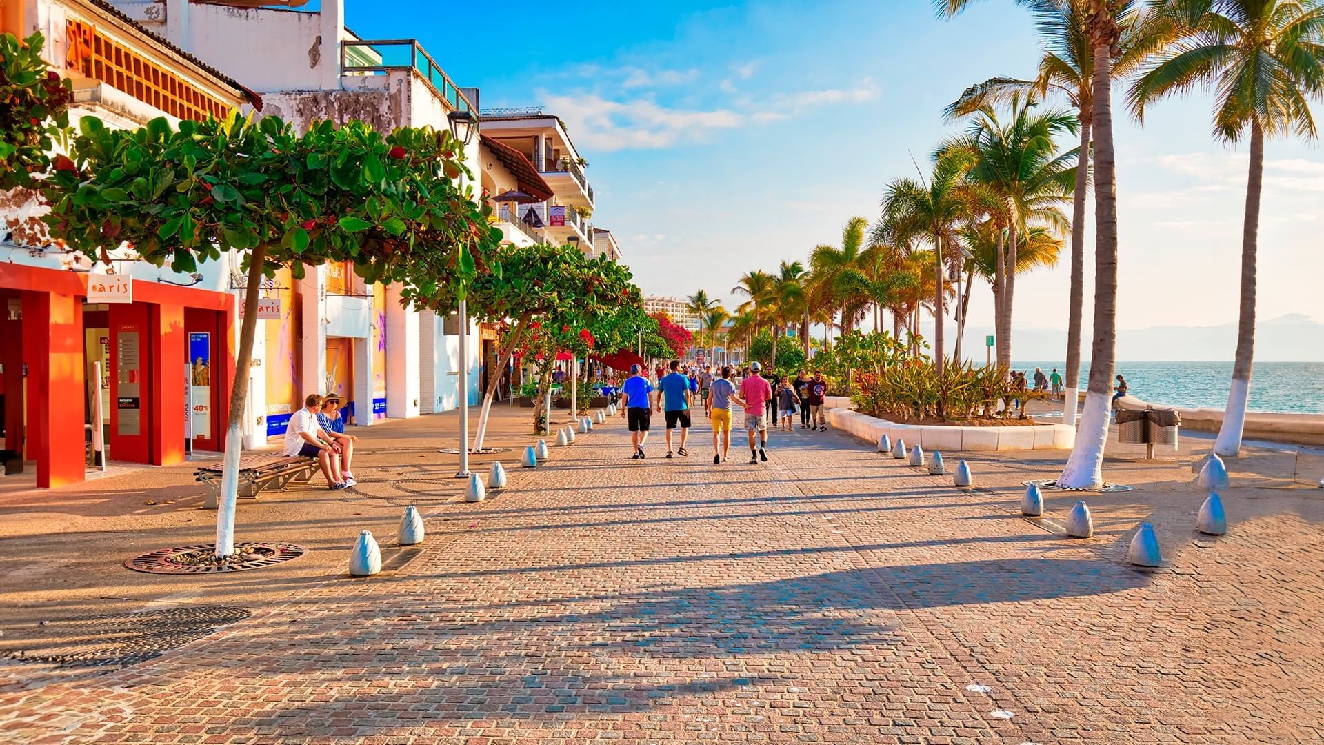 Niños sentados en las esculturas de La Rotonda del Mar en el Malecón de Puerto Vallarta