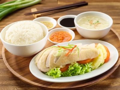 Hainanese Chicken rice served on a wooden plate at York Hotel Singapore
