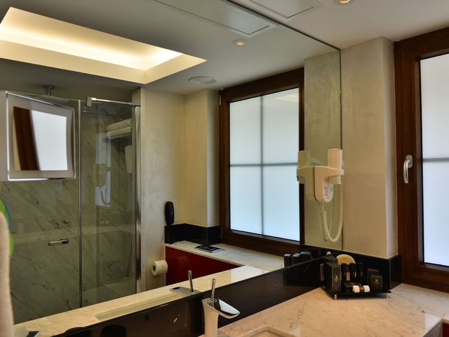 Modern bathroom with a marble vanity by a frosted window under a bright light in Executive Rooms at Warwick Ankara