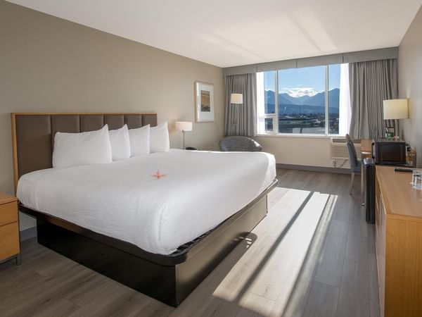 A king-sized bed with a pond view in a room.