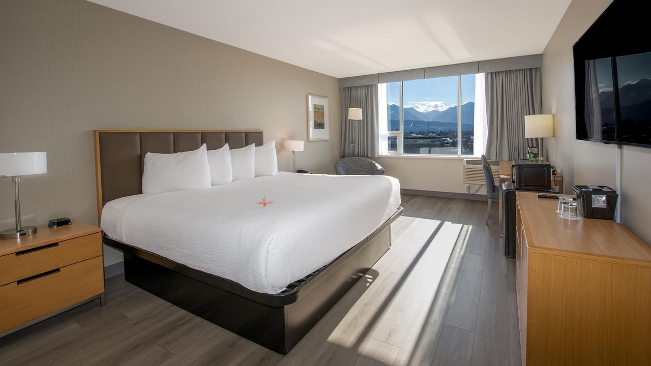 A king-sized bed with a pond view in a room.