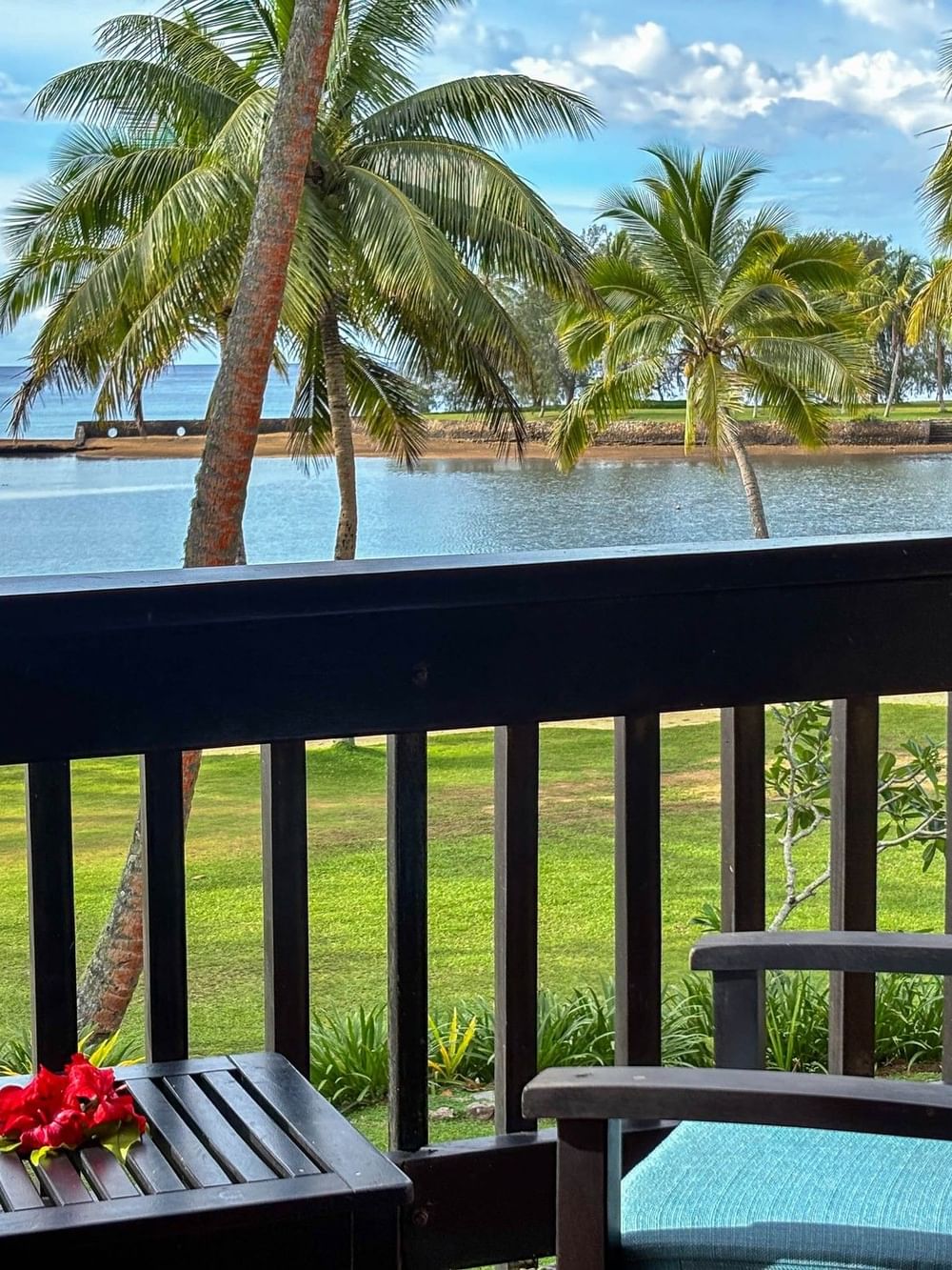 Suite balcony with ocean and palm trees view at The Naviti Resort in Korolevu.