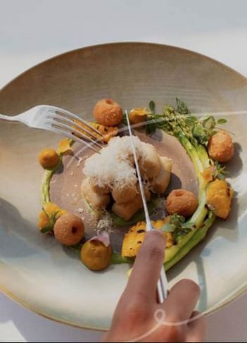 Gourmet gnocchi dish with cheese, corn, asparagus, and sauces, ready to be served at The Saujana Hotel Kuala Lumpur