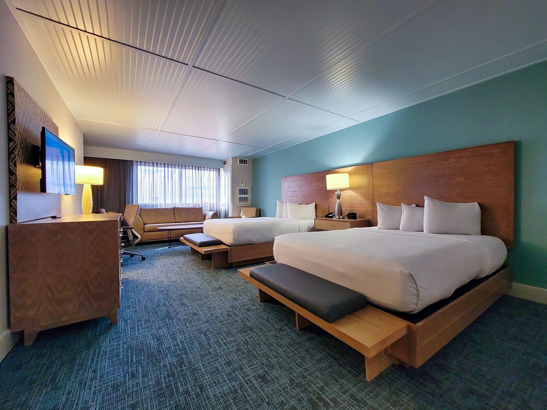 Double Queen Deluxe featuring two queen beds, a blue accent wall, and wood decor at Margaritaville Resort Biloxi