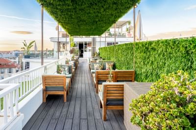 Relaxing outdoor rooftop patio lounge with cozy seating and lush green walls in Bonobo’s Bar at Splendid Hotel & Spa Nice