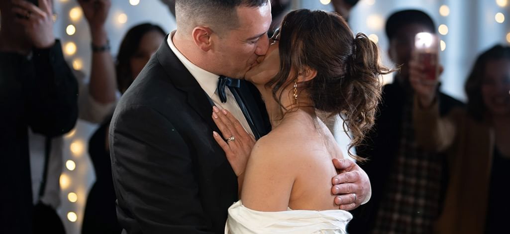 A newly married couple kisses on the dance floor of their mountain wedding venue in Canmore.