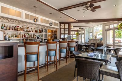 Restaurant and bar interior with dining tables and bar seating at Anchorage By The Sea