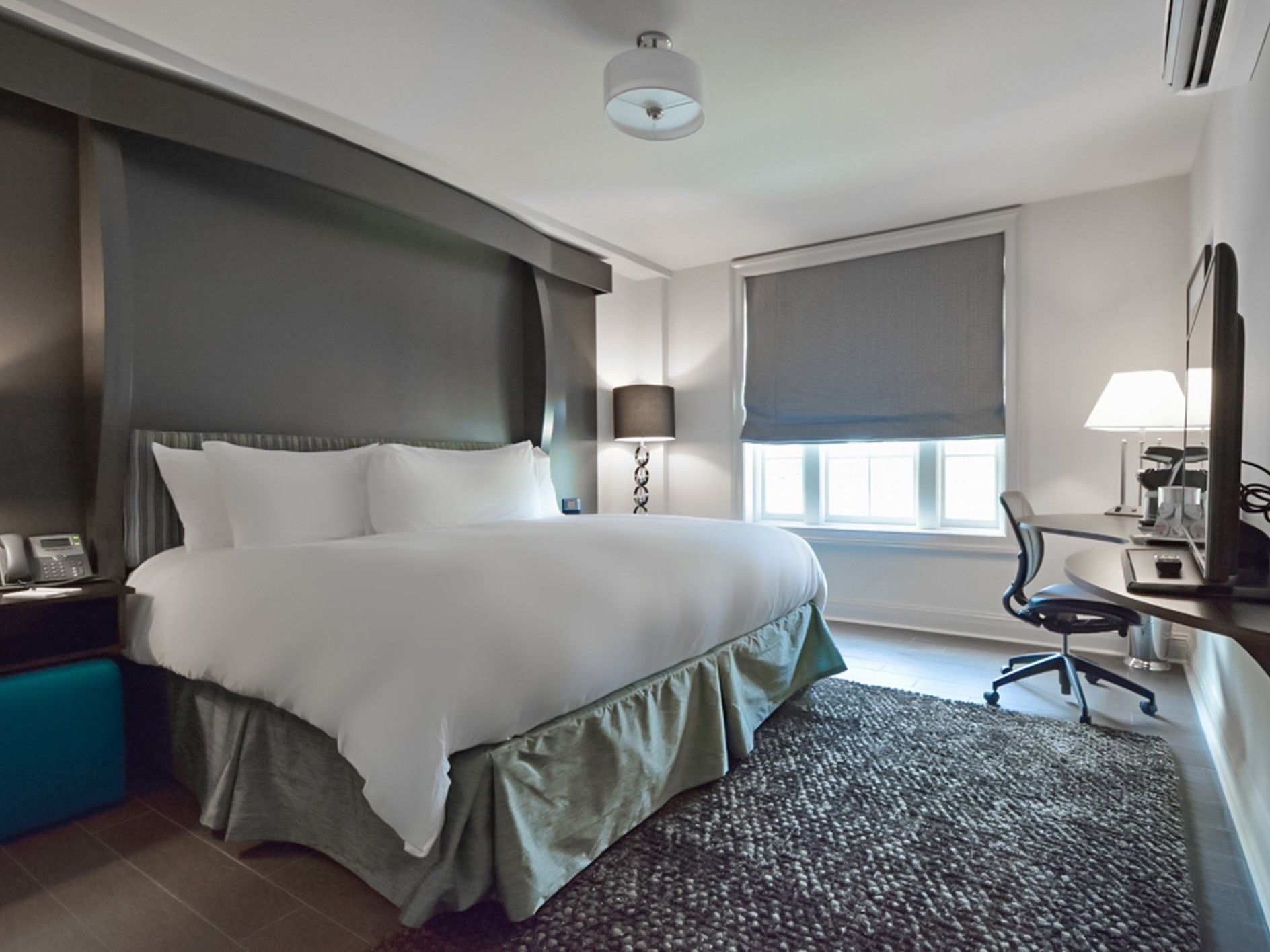 King Bed Residential View room at The White House Hotel with a large cozy bed, a TV, and a desk arranged by the window