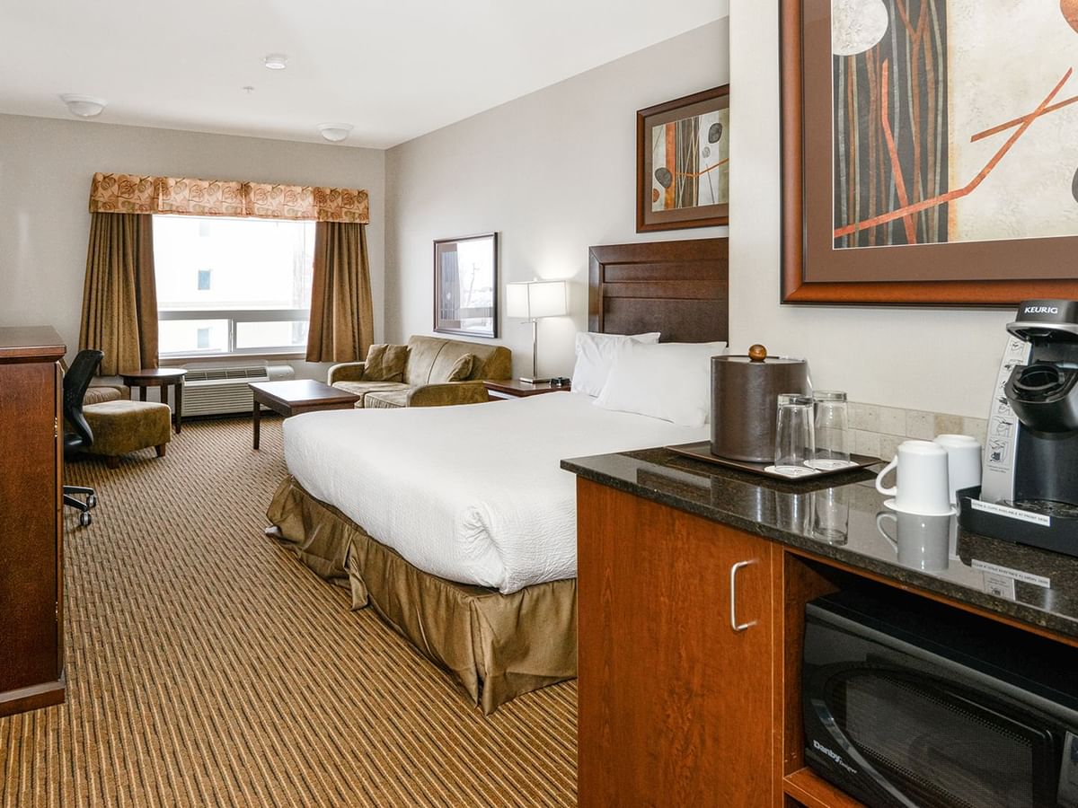 Hotel room with a king bed and a sofa bed, TV, work desk, chair, coffee machine and microwave