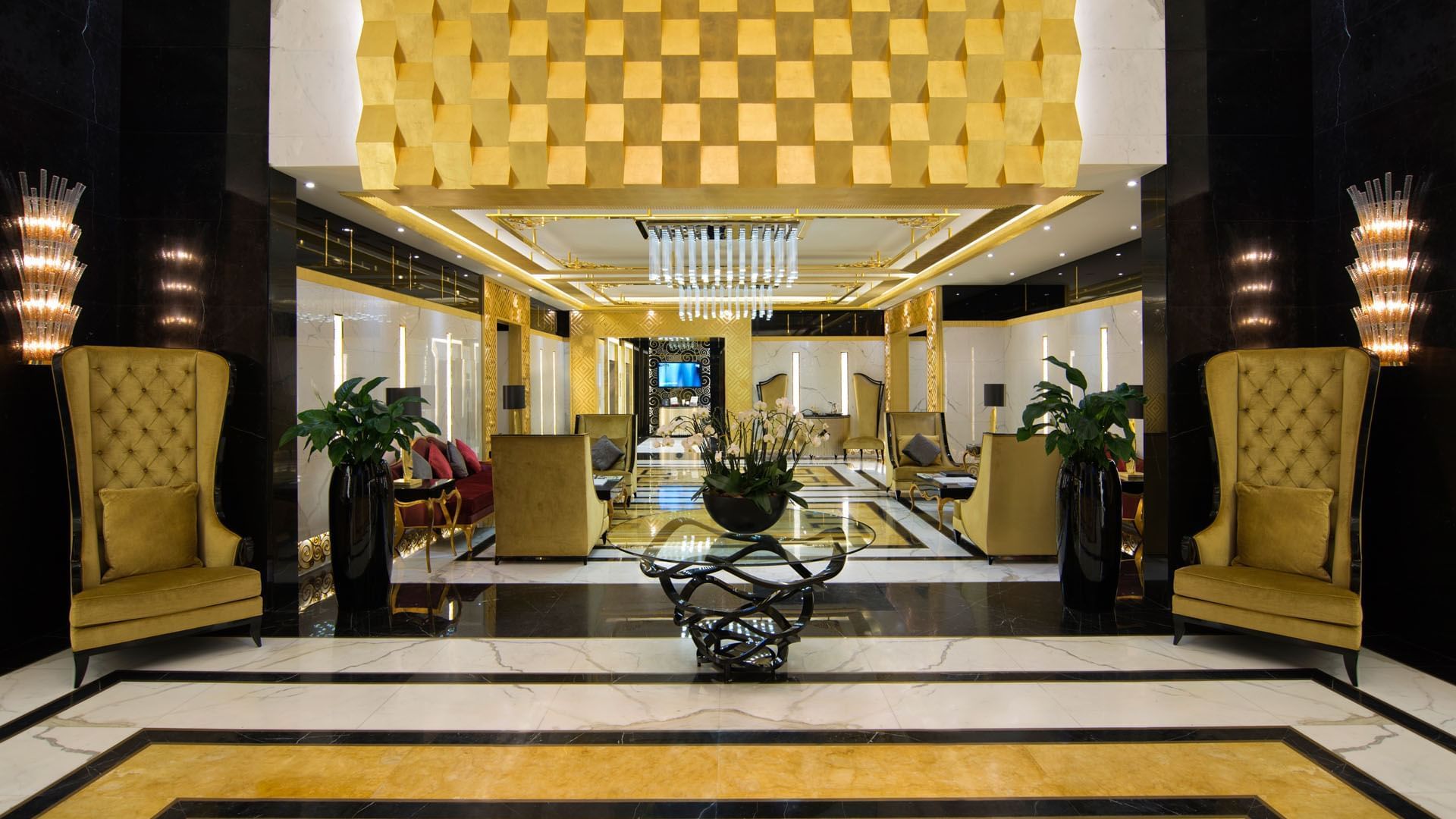 A grand lobby with a chandelier and a table at DAMAC Maison Dubai Mall Street