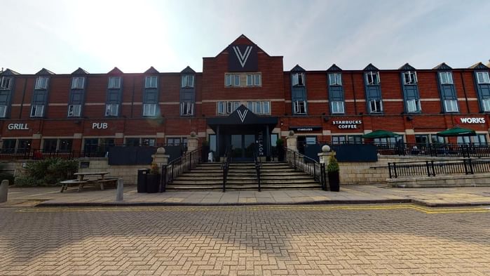 An exterior view of the hotel & car park at Village Hotels