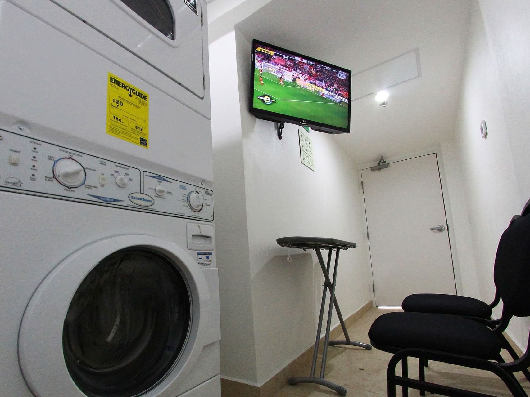 Interior of the hotel laundry room with a wall TV at One Hotels