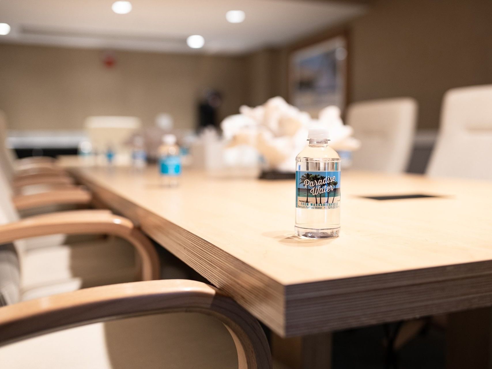 Branded Paradise Water bottle sitting on a wooden boardroom table at Margaritaville Resort Biloxi