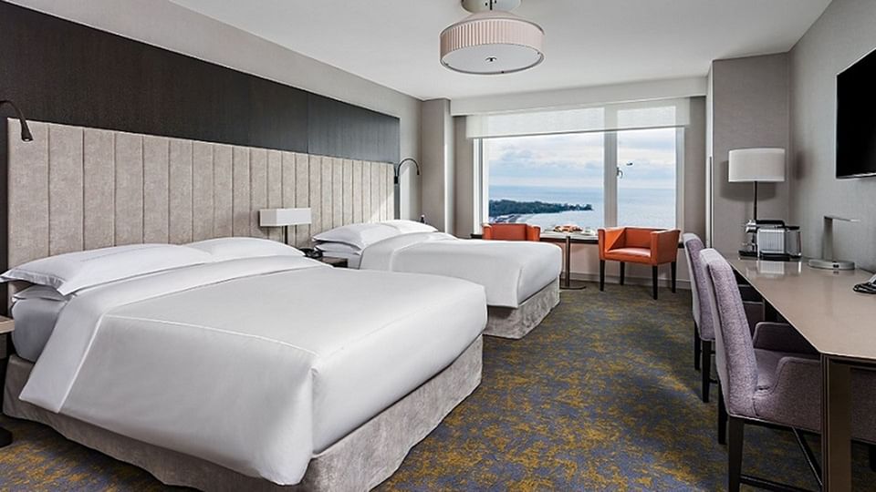 Espace de travail et télévision face au lit dans une chambre Premium à deux lits Queen à l'hôtel X Toronto