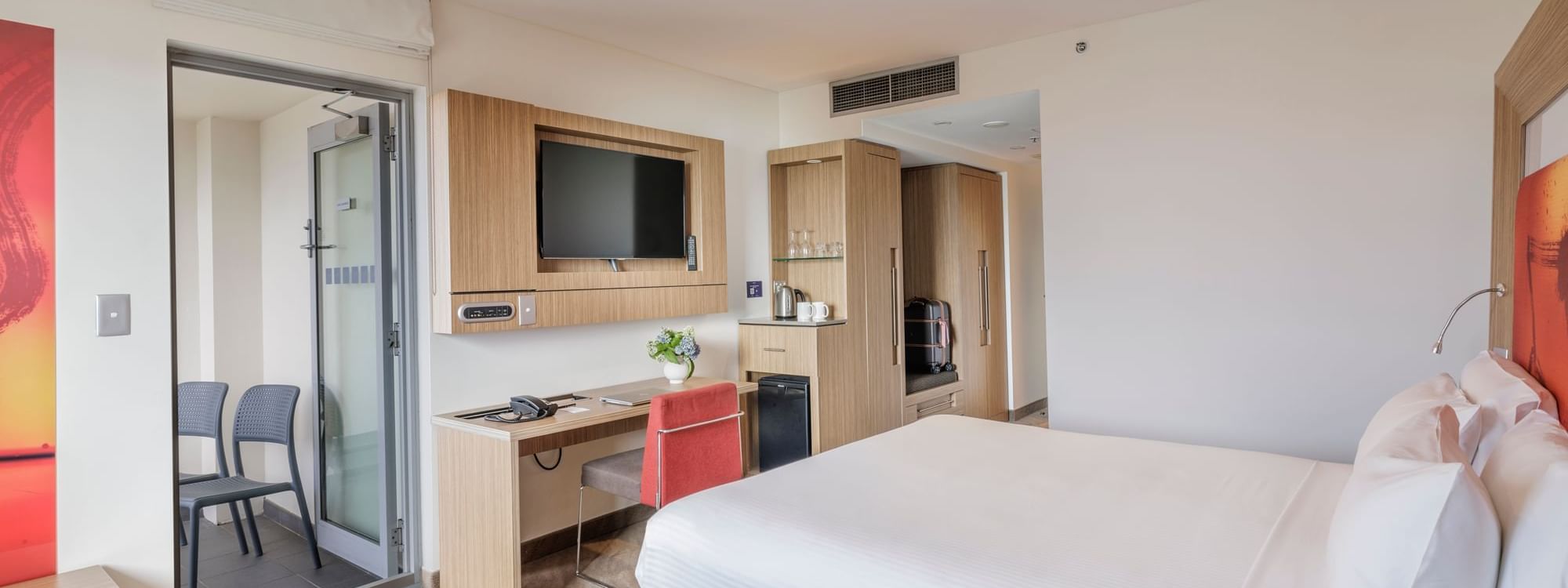 TV, work desk, and Coffee Station by the comfy bed in Balcony Room at Novotel Sydney Olympic Park