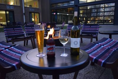 beer and wine on a table by a firepit