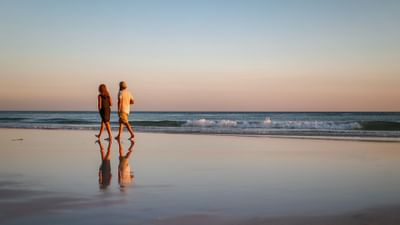 A couple walking by the beach near Falmouth Tides